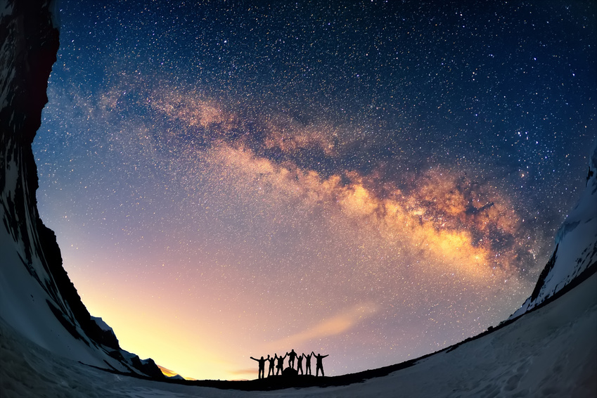Gruppe von Menschen vor dem Nachthimmel mit der Milchstraße